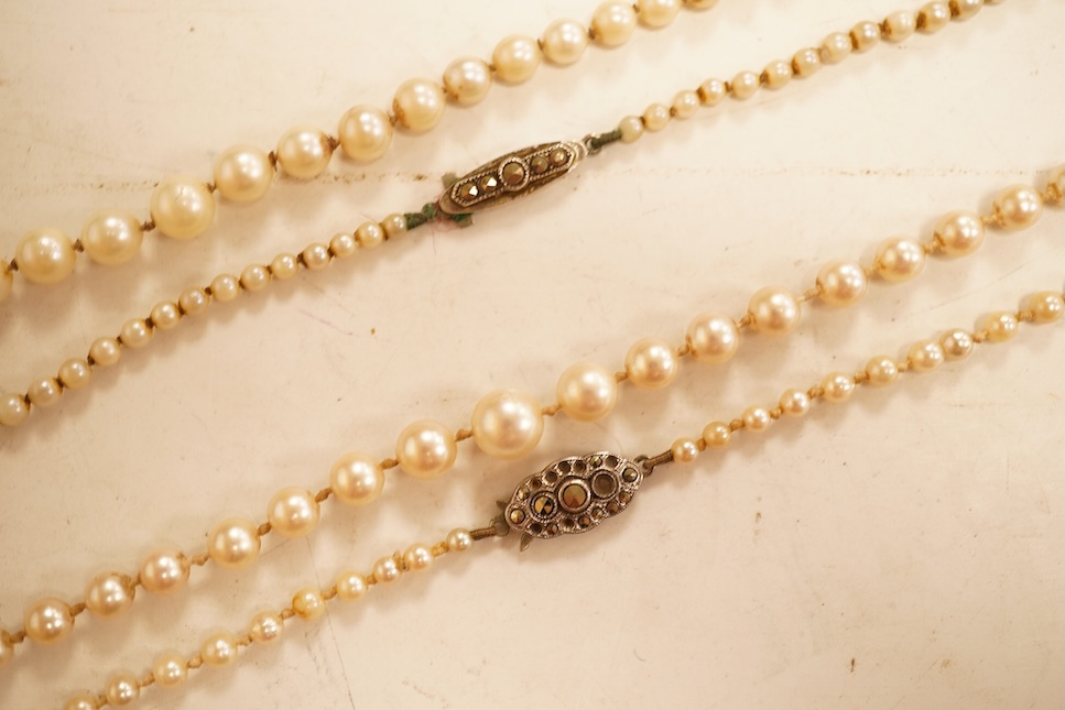 Two single strands graduated cultured pearl necklaces, both with marcasite set sterling clasps, longest, 64cm.